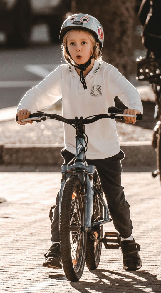 Ett barn på cykel med cykelhjälm.