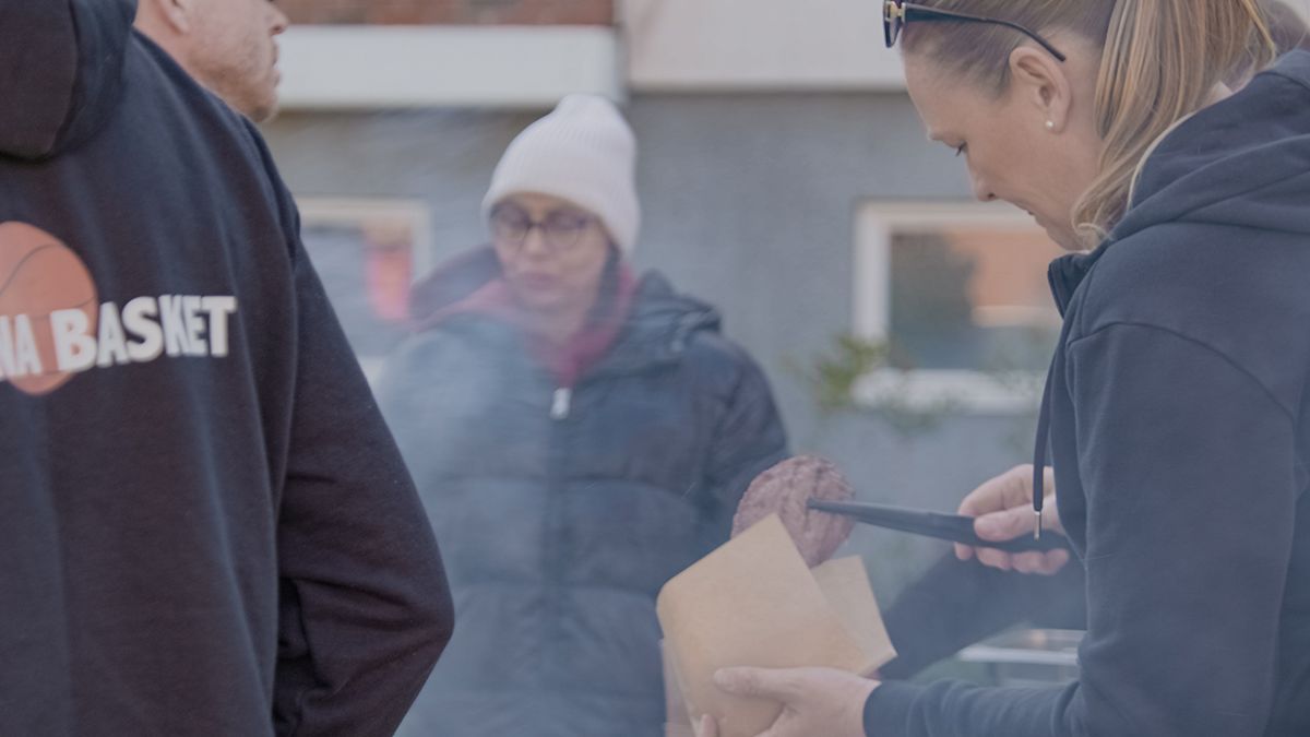 Personer som grillar hamburgare på en områdesaktivitet